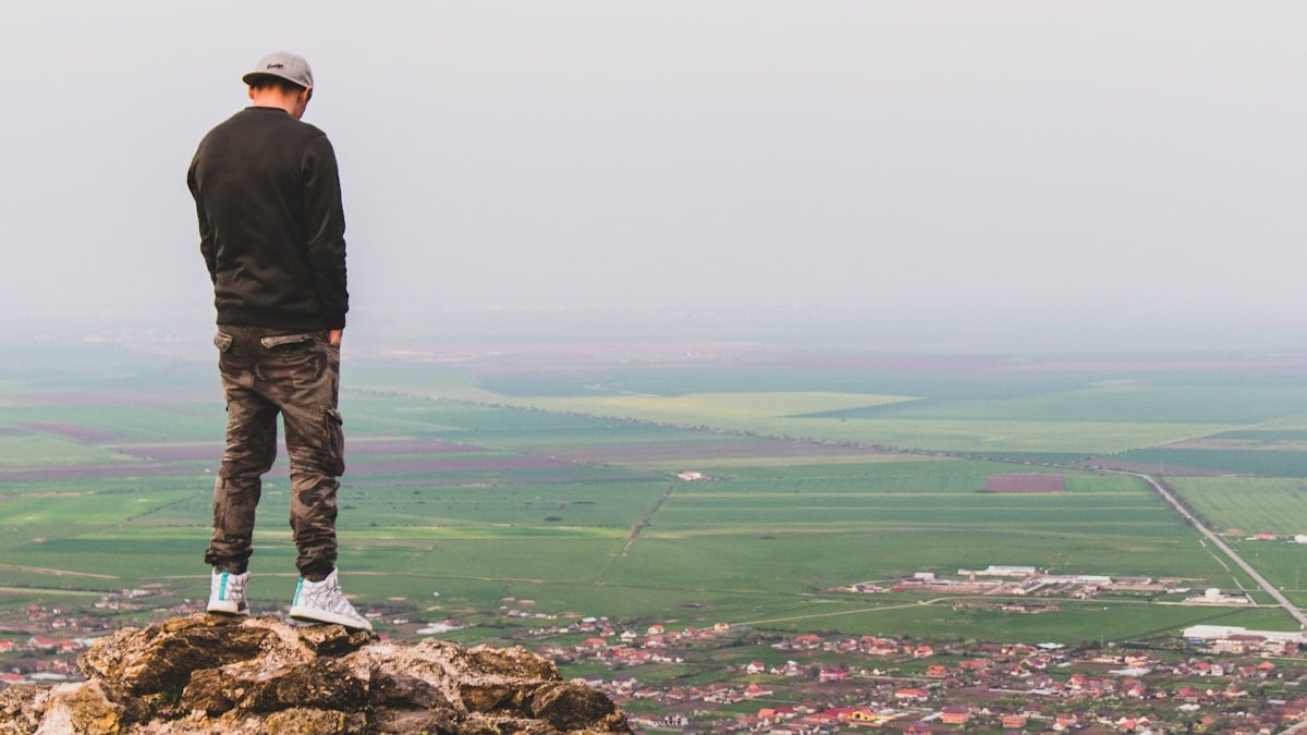 man hands on pocket at the top of cliff